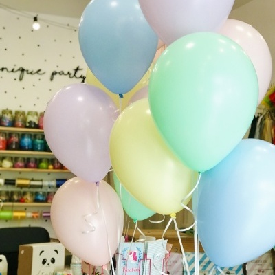 Balões de festa em tons pastel agrupados em loja decorada