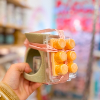 Difusor de cerâmica com pastilhas de cera amarela e fita rosa