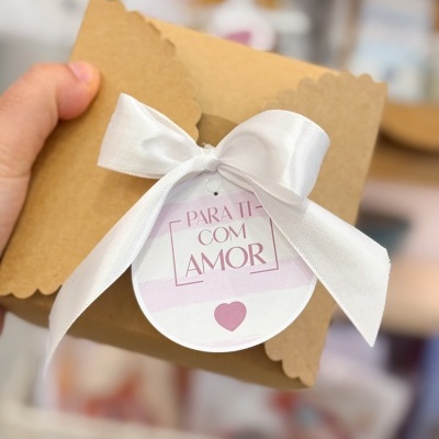 Caixa castanha decorada com fita branca e etiqueta com texto e coração cor de rosa