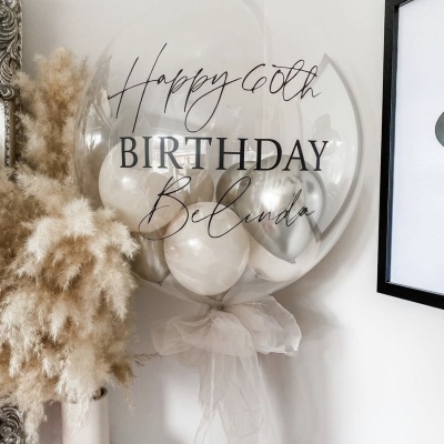 Balão transparente com mensagem de aniversário e balões internos prateados e brancos