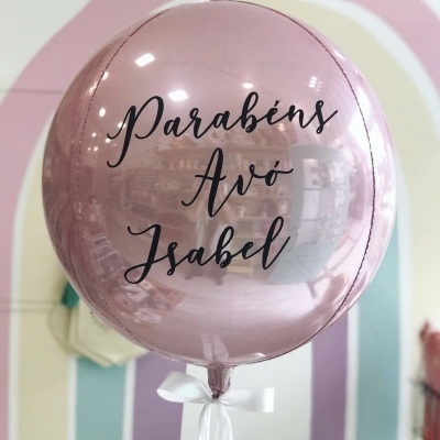 Balão rosa metálico com texto preto e fita branca