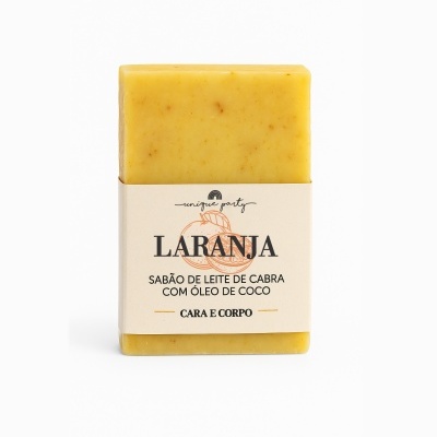 Sabão em barra amarelo com embalagem branca e texto LARANJA SABÃO DE LEITE DE CABRA COM ÓLEO DE COCO