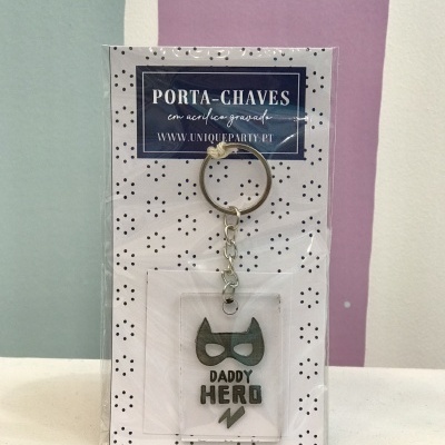 Porta-chaves acrílico com frase 'DADDY HERO' e máscara preta em embalagem com padrão de pontos pretos