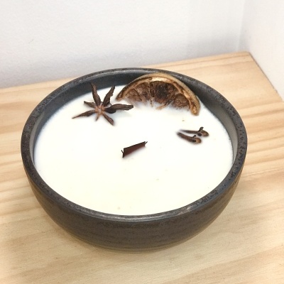 Vela decorativa em pote preto com especiarias naturais e rodela de laranja seca