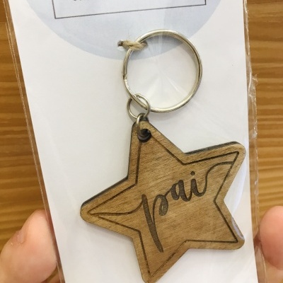 Porta-chaves de madeira gravada em forma de estrela com a palavra 'pai' e argola metálica