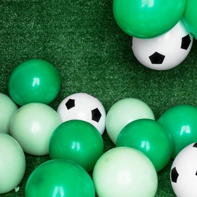 Bolas verdes e bolas brancas com padrão de futebol sobre relvado sintético