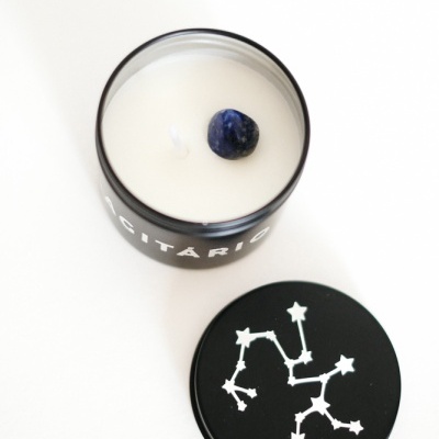 Vela branca em vidro preto com tampa preta com desenho de constelação