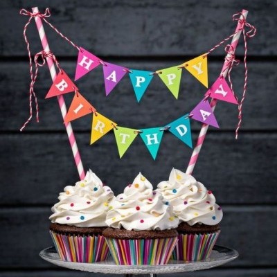 Três cupcakes com decoração de aniversário em forminhas listradas num prato de vidro