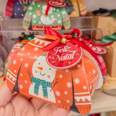 Embalagem de papel com padrão de Natal, boneco de neve e etiqueta com Feliz Natal