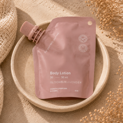 Embalagem rosa de Body Lotion BLOOM & LAVENDER com 50 ml em prato bege ao lado de tecido e flores secas.