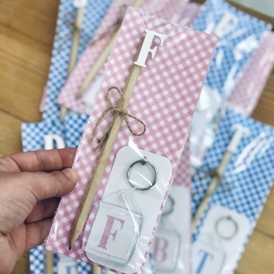 Chaveiros com lápis em embalagem rosa e azul quadriculada