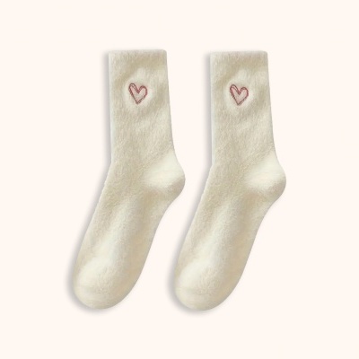 Par de meias creme com corações bordados vermelhos sobre fundo claro