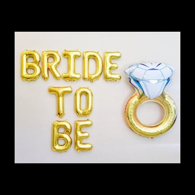 Balões dourados com texto BRIDE TO BE e balão em forma de anel de noivado