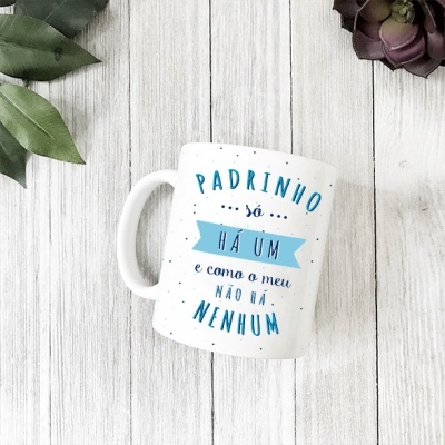 Caneca branca com texto azul e preto sobre madeira clara com folhas e suculenta