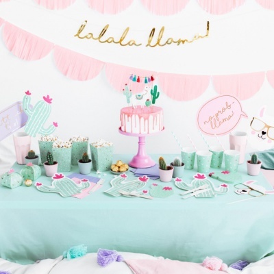 Mesa decorada com tema de llama e cactos, copos, pratos, bolo e enfeites coloridos