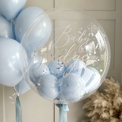 Balões azuis e transparente com confetes e inscrição Baby Bridge