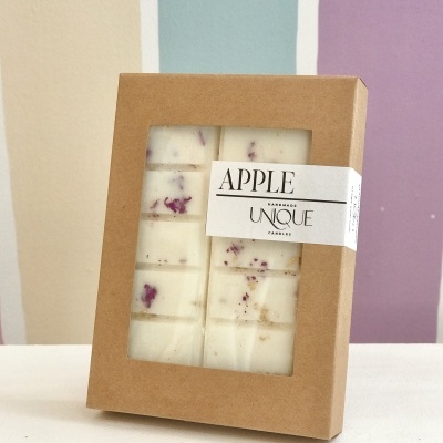 Barra de cera perfumada branca com pedaços roxos embalada em caixa de papel castanho com janela e etiqueta branca