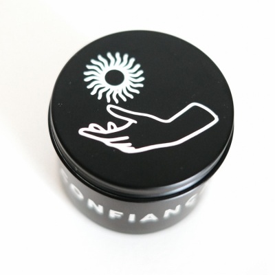 Pote preto redondo com desenho branco na tampa e texto 'CONFIANÇA' na lateral