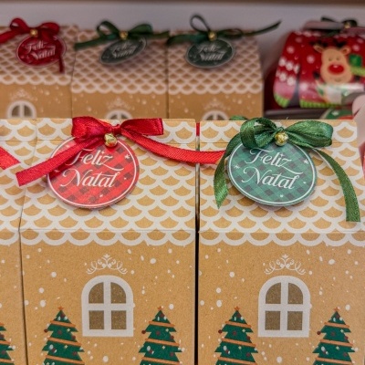 Caixas de presentes natalícias em cartão com cordões e etiquetas de Feliz Natal