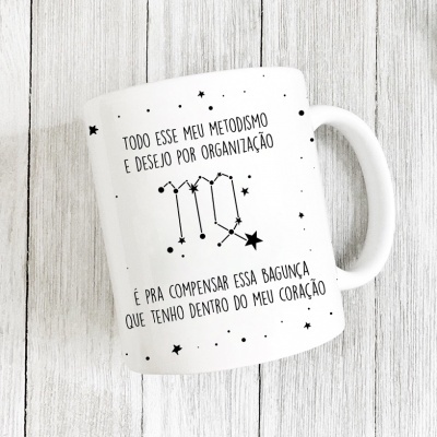Caneca branca com frase em português e desenhos de estrelas pretas