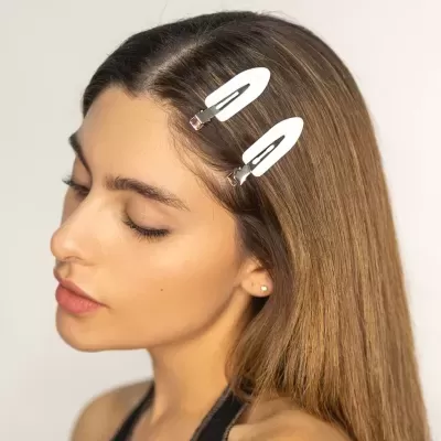 Mulher com molas de cabelo brancas em cabelo castanho liso
