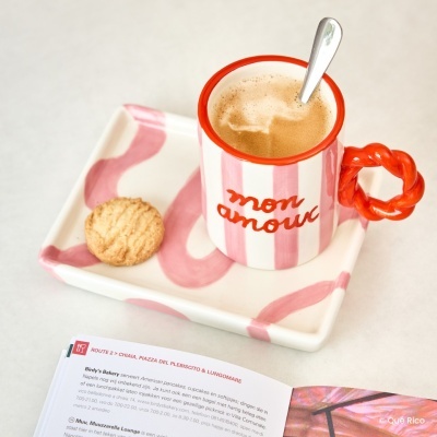 Chávena e tabuleiro cerâmicos rosa e branco com texto mon amour, biscoito, colher e revista