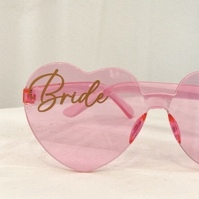 Óculos de sol rosa coração com inscrição Bride em dourado