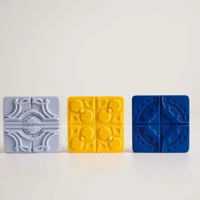 Azulejos decorativos quadrados em cinza claro, amarelo e azul com diferentes padrões.