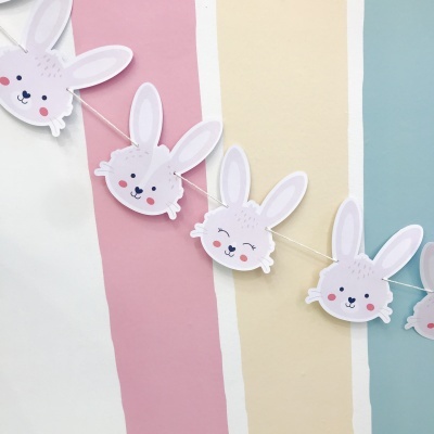 Guirlanda de coelhos de papel decorativa com fundo listrado colorido