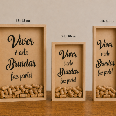 Três quadros de vidro com rolhas de cortiça, moldura de madeira e frase em português, sobre mesa com vaso e livros Kinfolk.
