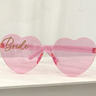 Óculos de sol coração cor-de-rosa com a palavra Bride em dourado.