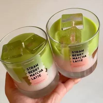 Velas bicolor rosa e verde em copos de vidro com cubos verdes decorativos e etiqueta rosa