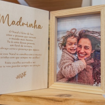 Moldura de madeira clara com foto de mulher e criança sorridentes e mensagem para Madrinha gravada.