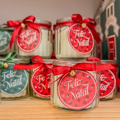 Velas de Natal em frascos de vidro com etiquetas e laços coloridos