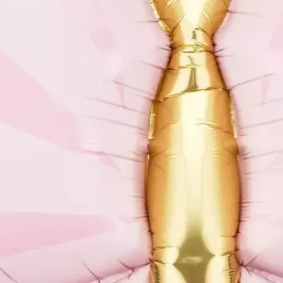 Balão dourado metálico em fundo rosa