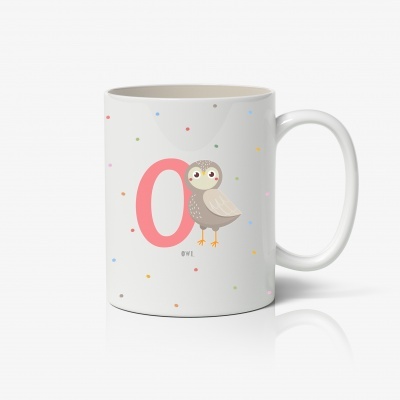 Caneca branca com design colorido e coruja ao lado da letra O