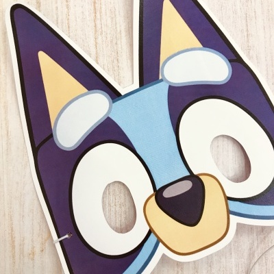 Máscara de papel com rosto de cão azul e roxo com recortes para olhos