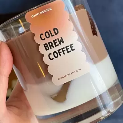 Copo de vidro com bebida Cold Brew Coffee e etiqueta da marca