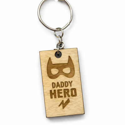 Porta-chaves retangular de madeira com texto DADDY HERO e máscara de super-herói gravados.