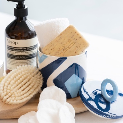 Produtos de cuidados pessoais com sabonete, escova, frasco e recipiente cerâmico azul e branco