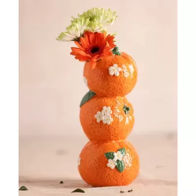 Vaso decorativo de cerâmica em forma de laranjas empilhadas com flores naturais