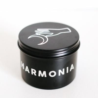 Frasco preto com tampa e texto 'HARMONIA' em branco