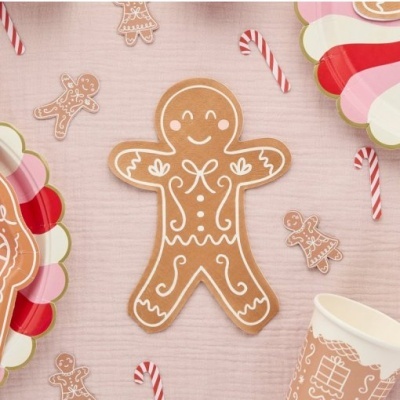 Biscoito homem de gengibre decorado com glacê branco e doces de Natal em fundo rosa