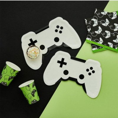 Pratos em forma de comando videojogo, copos verdes com comandos, guardanapos pretos com comandos, fundo preto e verde