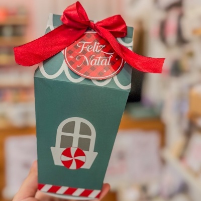 Embalagem de presente de papel verde decorada com janela e doce, com fita e etiqueta de Feliz Natal.