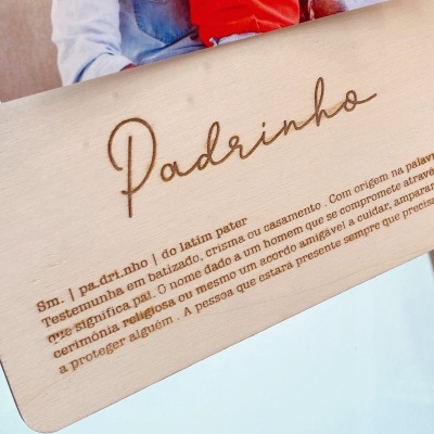 Placa de madeira com gravação a laser da palavra 'Padrinho' e texto explicativo em português.