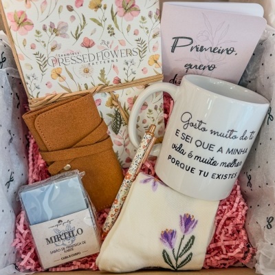 Kit de presente com caderno floral, caneca com texto, caneta decorada, sabonete Mirtilo, carteira castanha e saco de tecido bordado num caixa com papel rosa