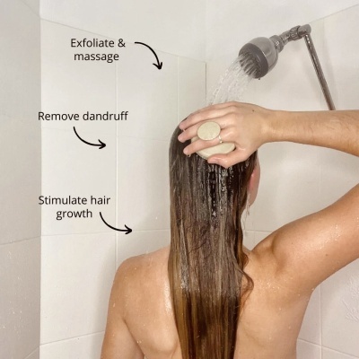 Pessoa toma banho, utilizando acessório para massagem no couro cabeludo