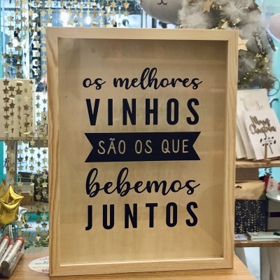 Quadro decorativo em madeira clara com texto em português sobre vinhos