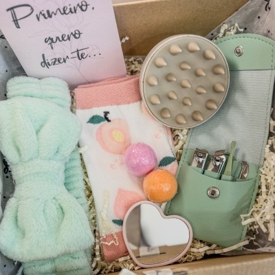 Conjunto de cuidados pessoais em caixa de papelão com toalha, meias, espelho, sais de banho, escova e estojo de unhas